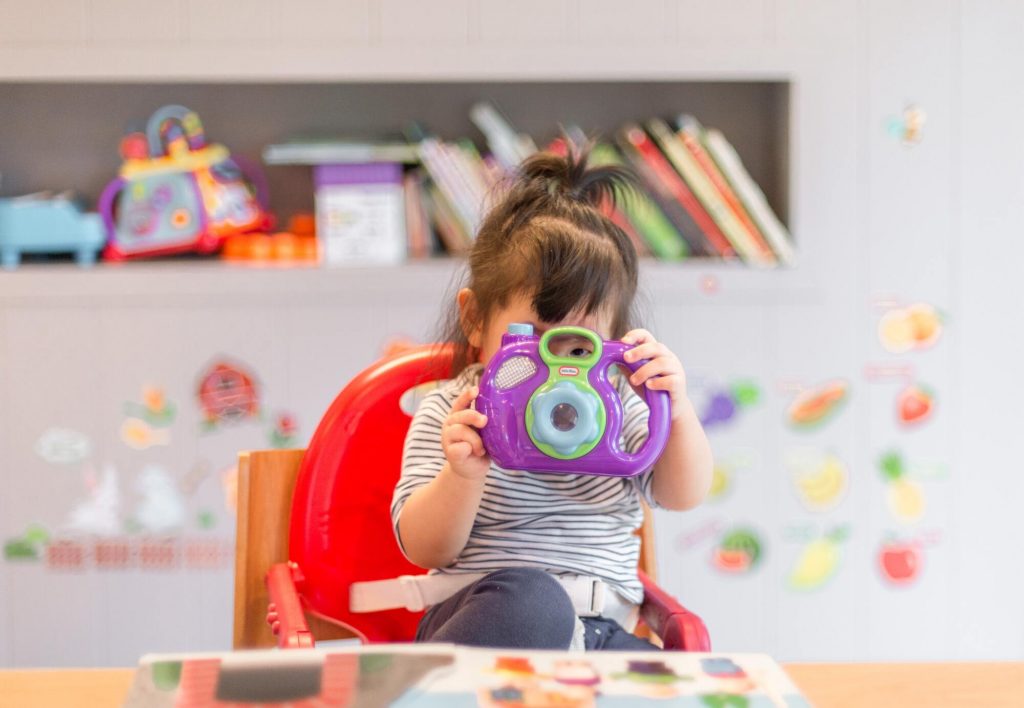 Enfant jouant dans une salle de jeux avec un appareil photo