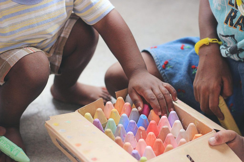 Enfant et parent jouant ensemble avec des craies dans une salle de jeux pour enfants